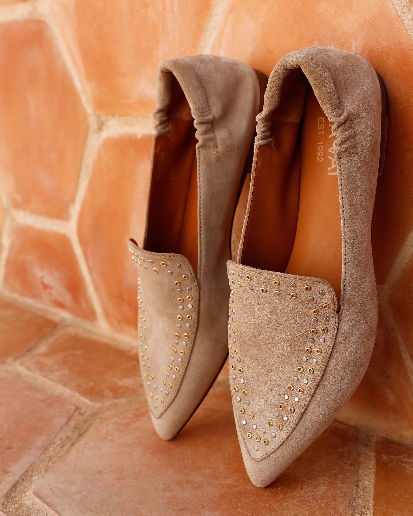 Beige suède VIA VAI Lola Gabriel dames loafers, rechtopstaand tegen stenen muur.