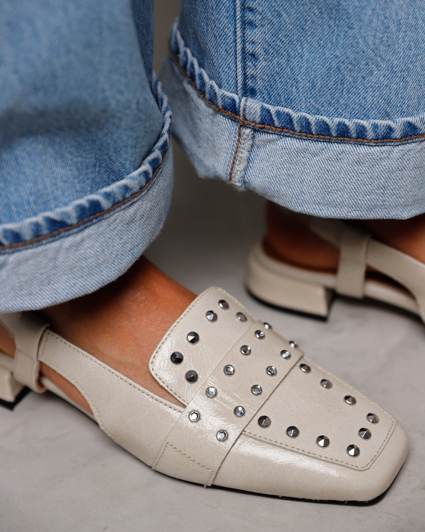 Detailfoto aan de voet gedragen met denim jeans, VIA VAI beige leren dames slingbacks Julie Damian.